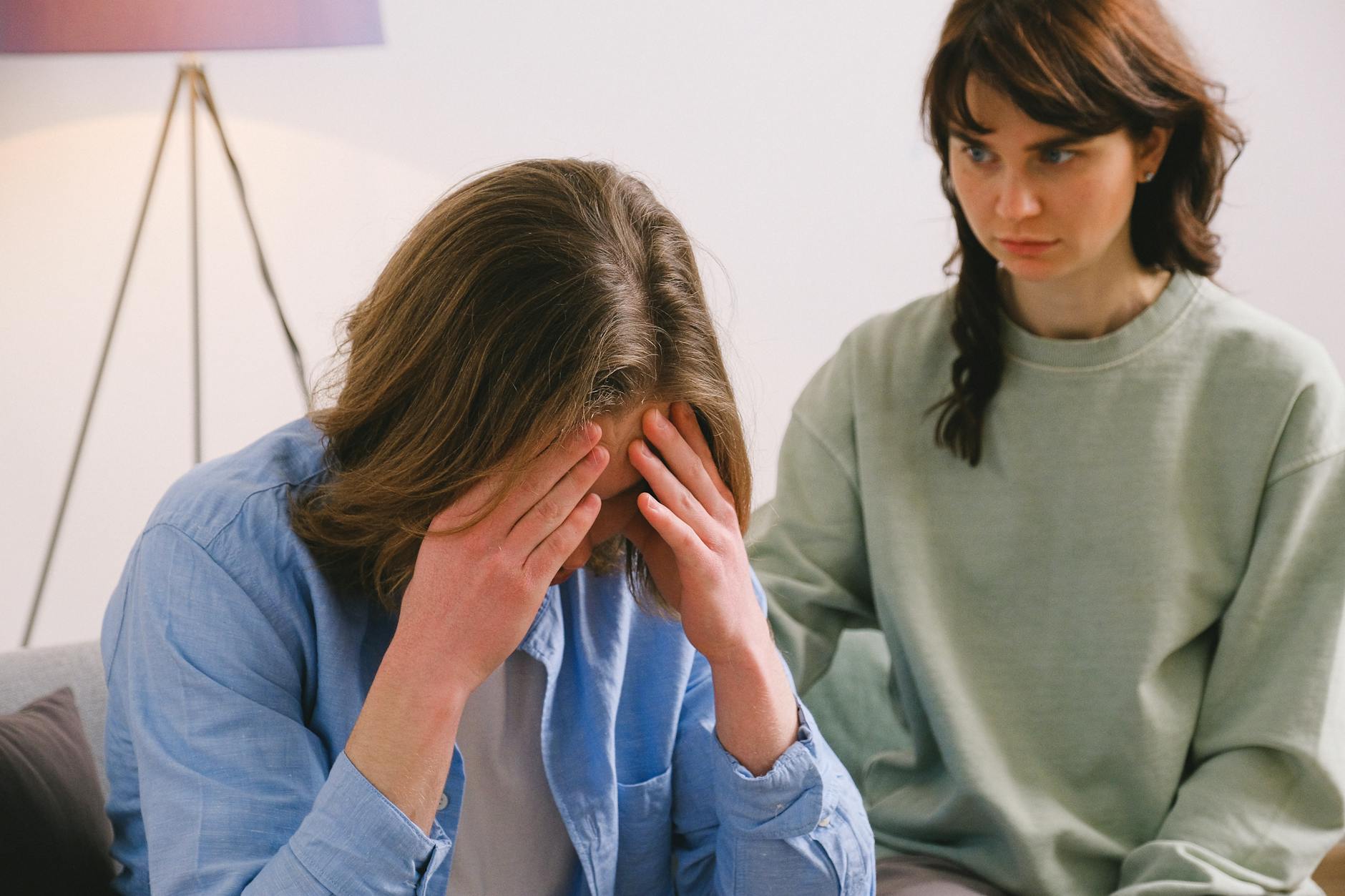 A couple in a tense discussion indoors, depicting stress and mental health focus.